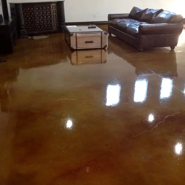 High-gloss copper stained concrete floor in a living room with leather seating