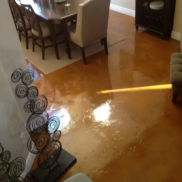 Copper stained concrete floor in a dining room with timber furniture