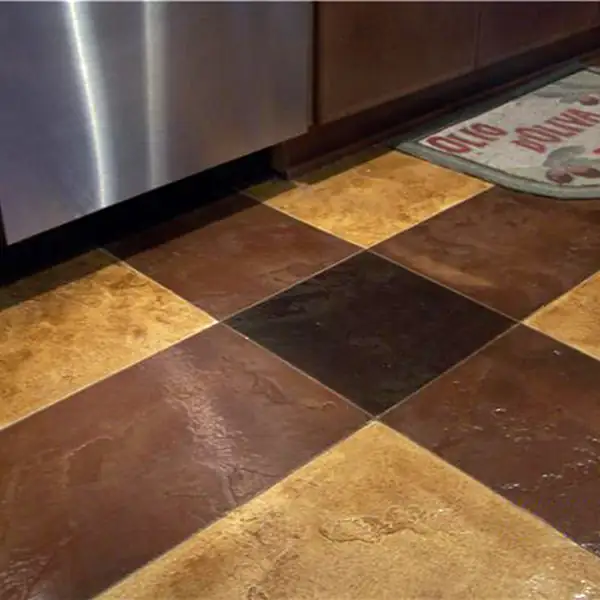 Checcurboard stained concrete floor in gold and dark brown at a kitchen bench