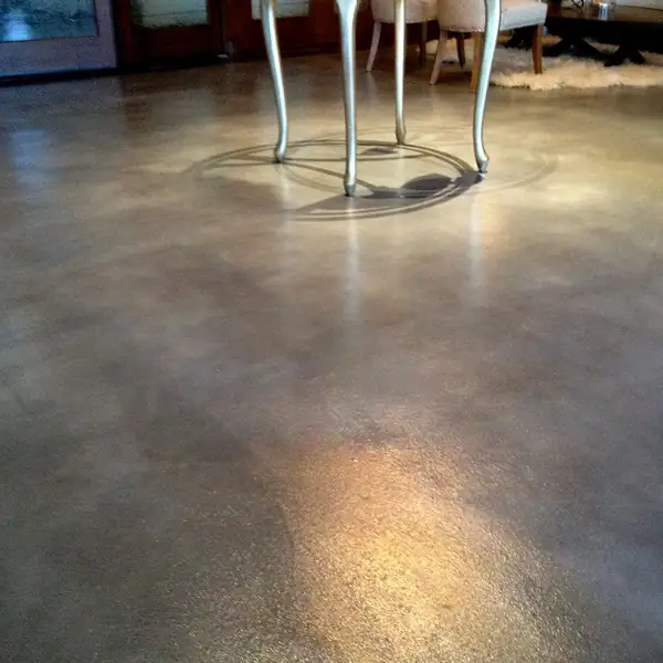 Gray and tan stained concrete entry floor with a dining table