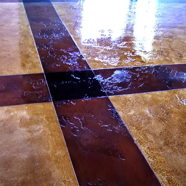 Stained concrete floor with a dark cross inlay running through it