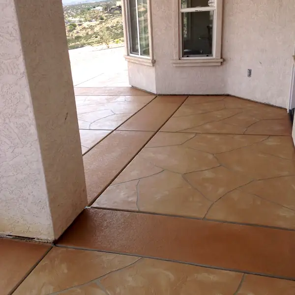 Terracotta stained floor scored in a tile pattern beside a window