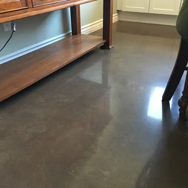 Polished brown concrete floor beneath a timber console table