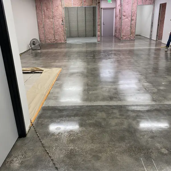 Polished concrete floor in a building under construction with framed walls