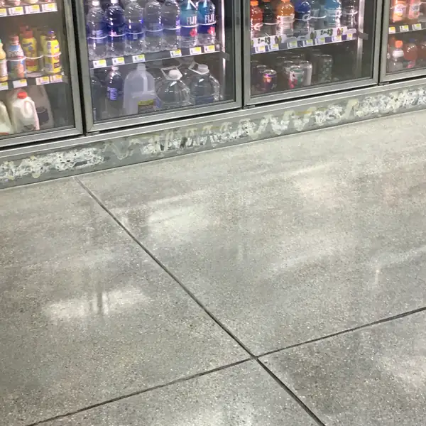 Polished concrete floor in a convenience store beside the drinks fridges