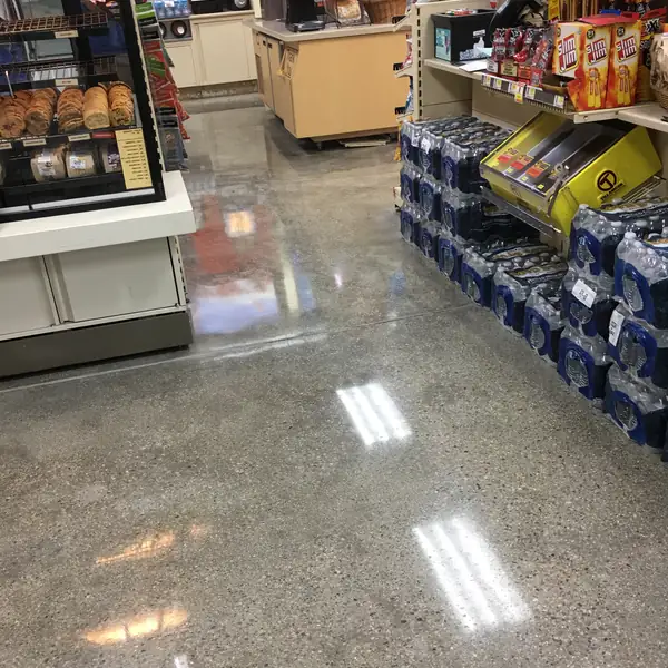 Polished concrete store floor with stacked drinks pallets and shelving