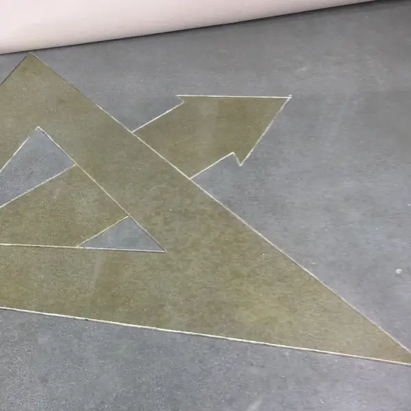 Polished concrete floor with a gold arrow graphic cut and stained into it