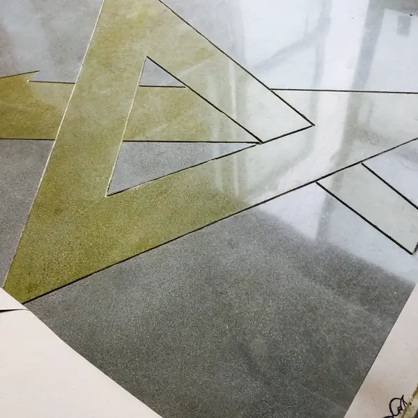 Close view of a gold stained triangle inlay in polished concrete