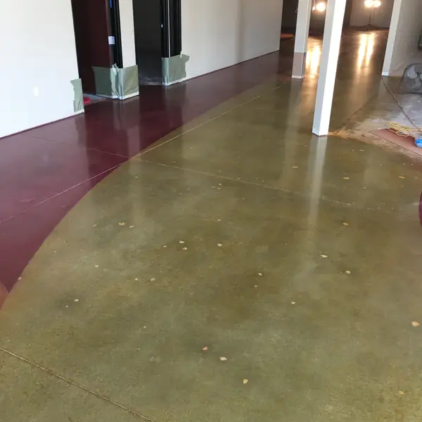 Polished floor in olive and maroon curving through a lobby