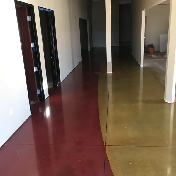 Polished stained floor in olive and deep red running down a corridor