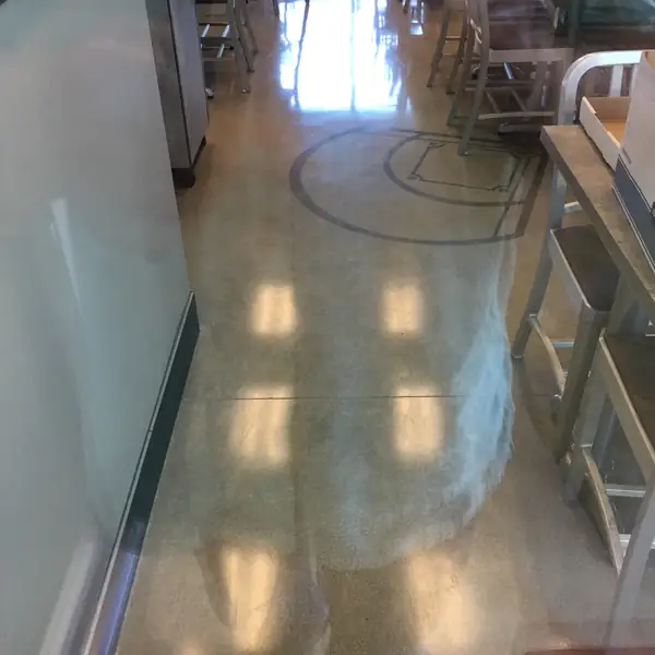 Polished concrete floor with a saw-cut circle in a cafeteria seating area