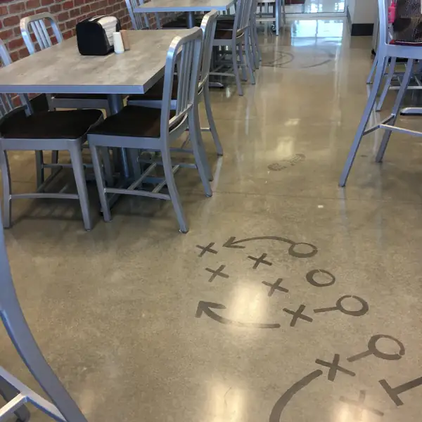 Polished floor with an X and O play diagram in a cafeteria seating bay