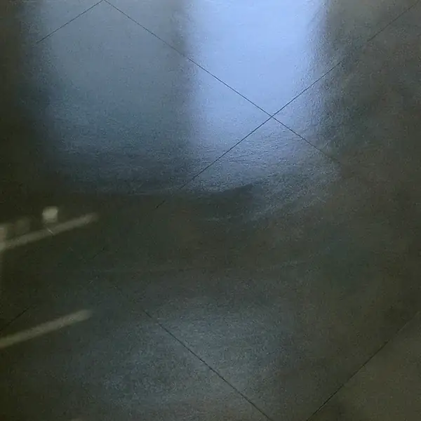 Dark green-gray polished concrete floor with a saw-cut joint