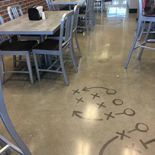 Play diagram cut into a polished cafeteria floor with bar seating above