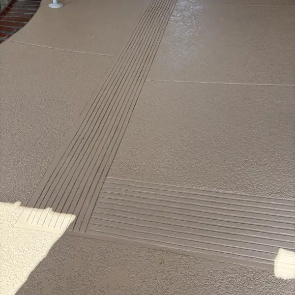 Grooved non-slip ramp edge in a tan textured deck coating
