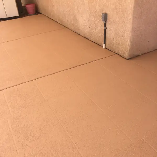 Terracotta textured pool deck meeting a stucco wall
