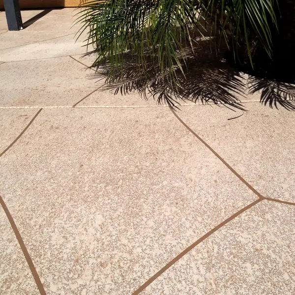 Tan textured patio broken up by scored joint lines