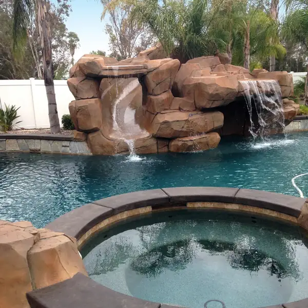 Restained rock grotto above a pool and spa