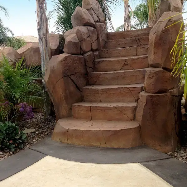 Restained rock staircase leading up beside a pool