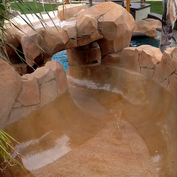 Restained faux rock waterslide running into a pool
